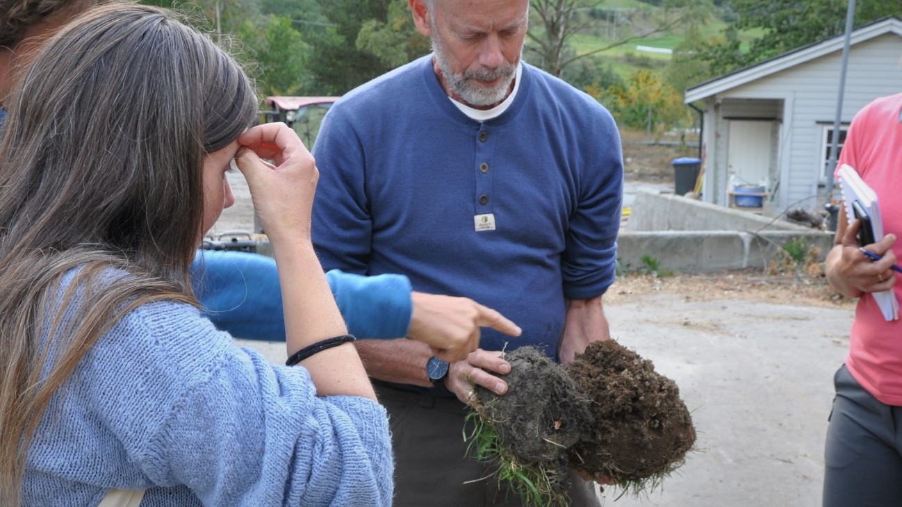 Jordklump og fire personer står rundt. 