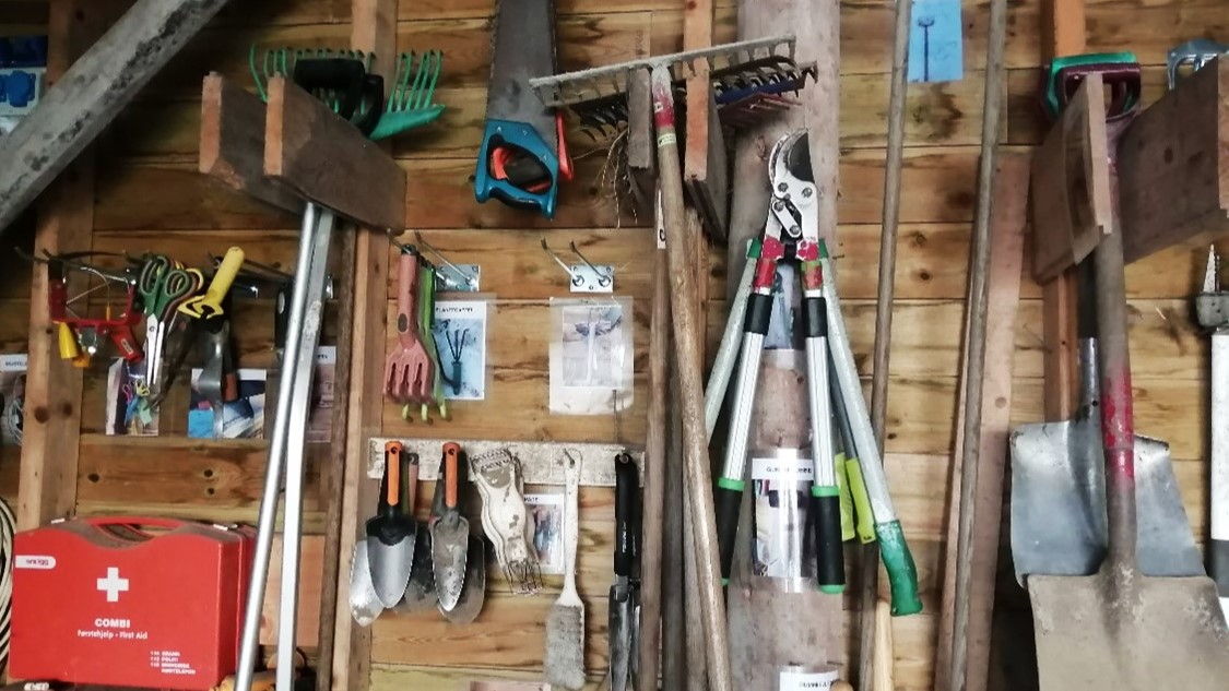 Masse hageverktøy på en vegg
