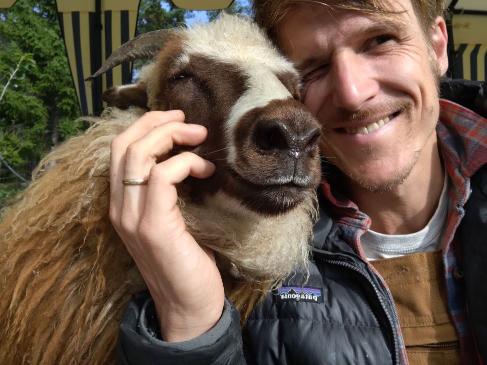 En gutt og en sau med horn.