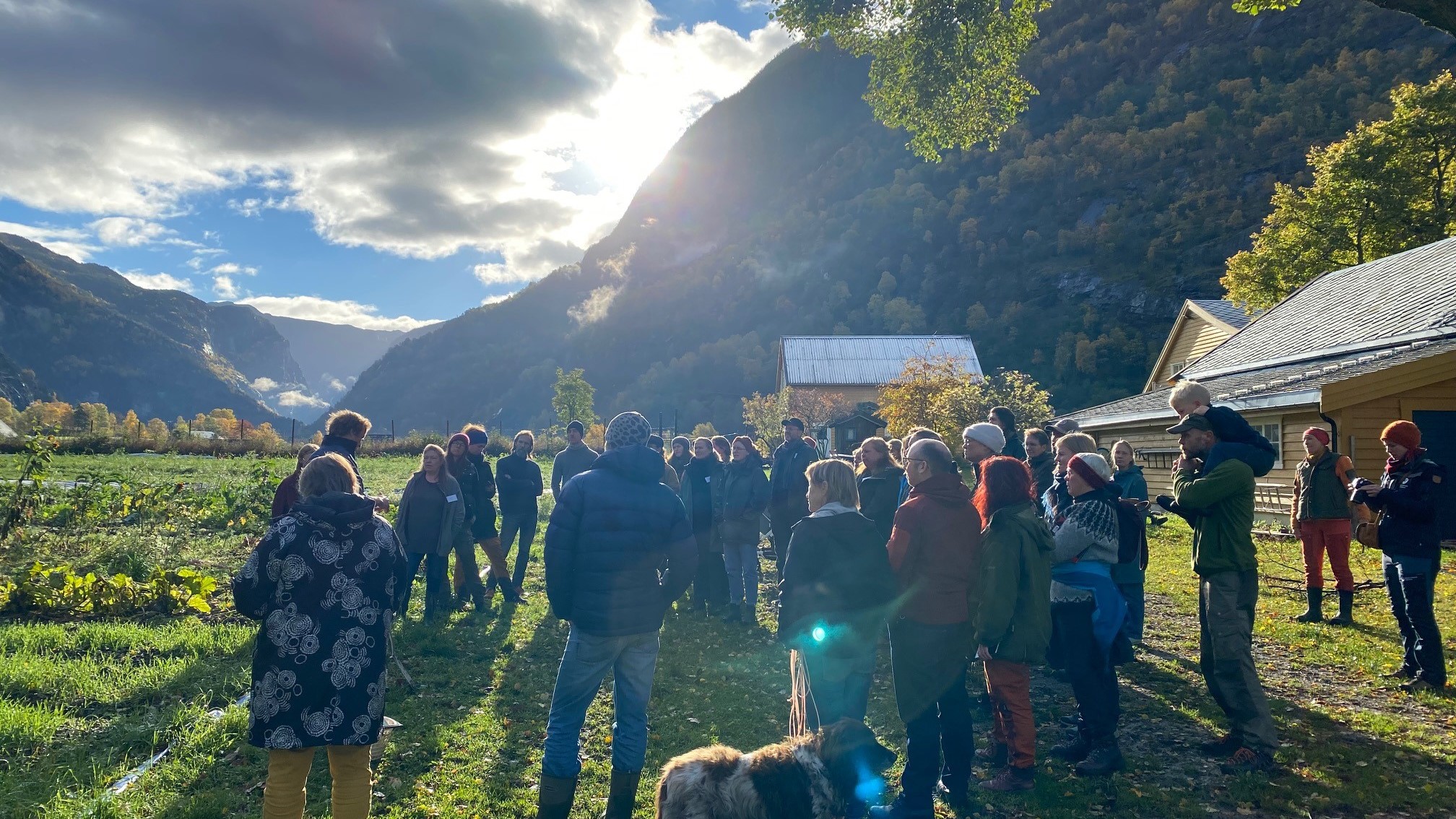 Mange mennesker i motsol i et landskap med fjell
