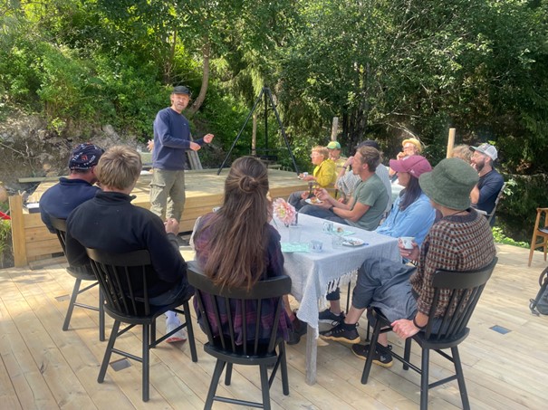 Mennesker som sitter og står rundt et bord